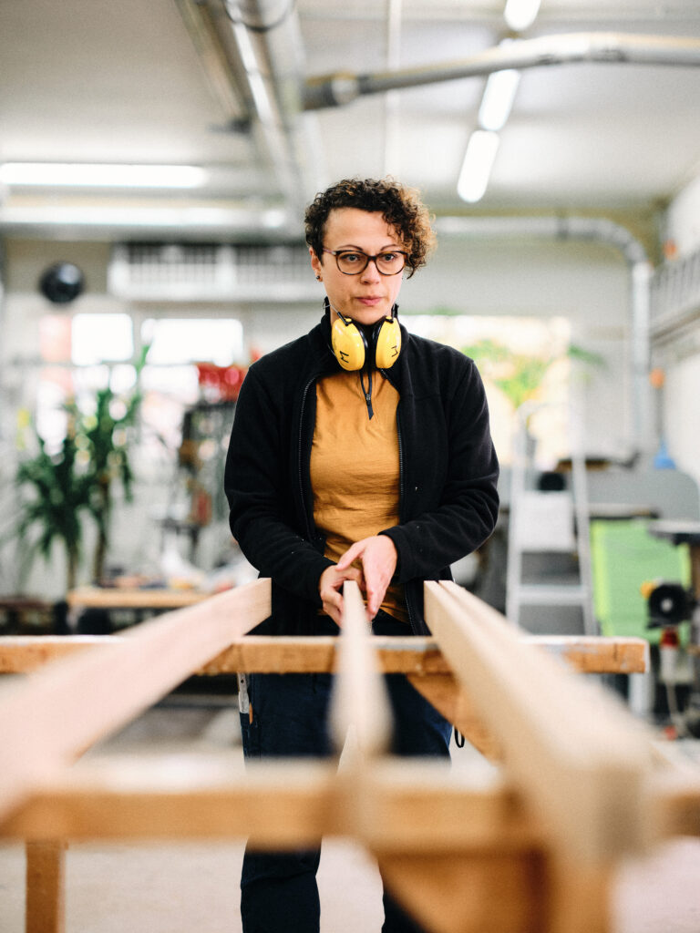 Katja Kammerer richtet in der Werkstatt Holzlatten aus.