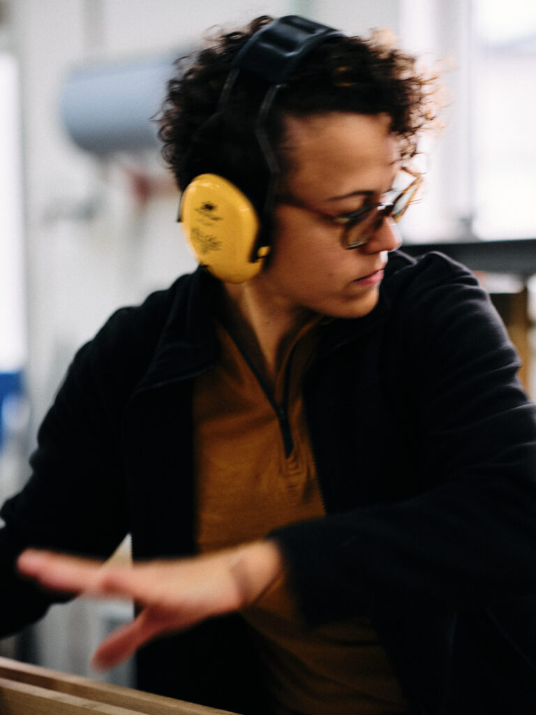 Katja Kammerer hantiert an einer Maschine in der Werkstatt.