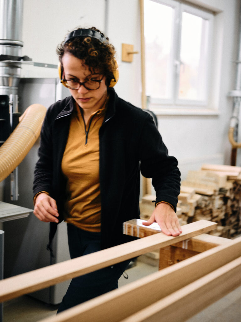 Katja Kammerer legt mehrere Latten zum Hobeln bereit.