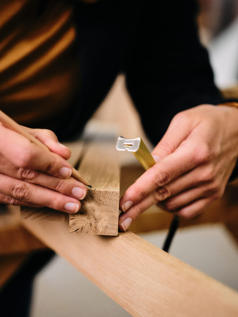 Katja Kammerer zeichnet eine Markierung auf ein Holzprofil.