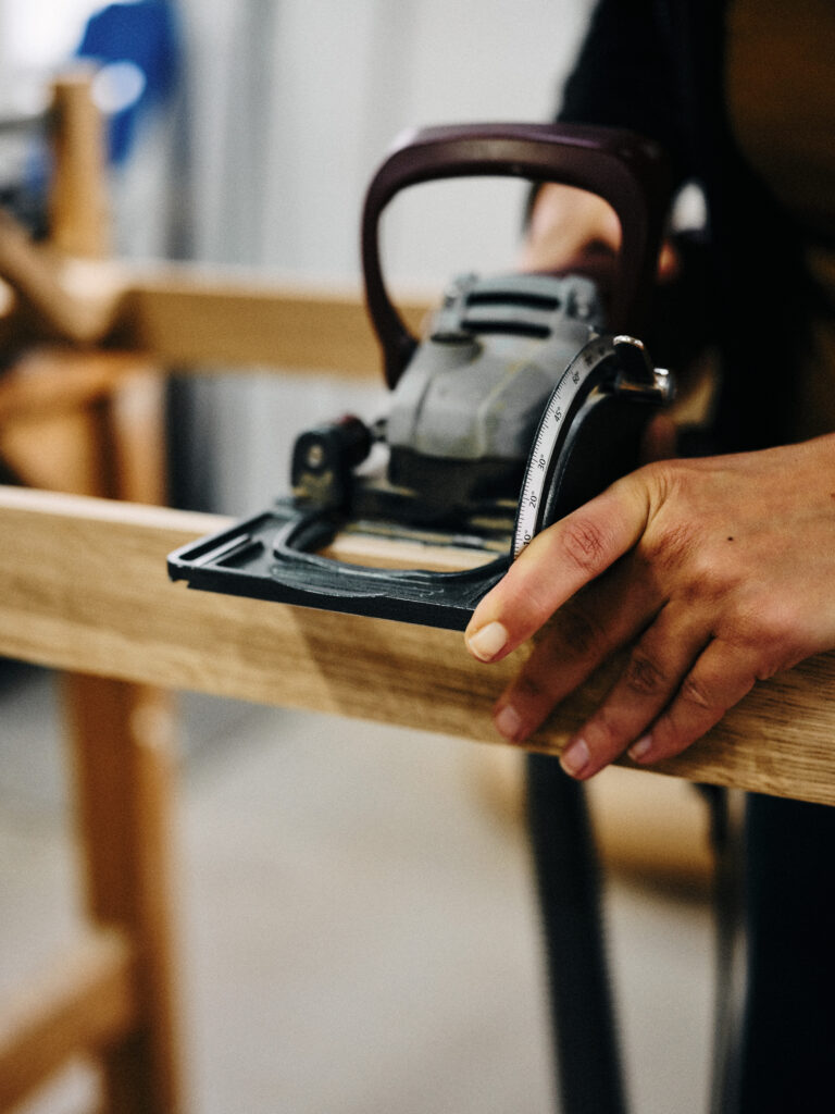 Katja Kammerer fräst mit einer Flachdübelfräse Verbindungsnuten in einen Rahmen.