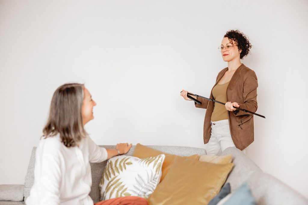 Eine Immobilienberaterin bespricht mit einem Kunden Möglichkeiten zur Umgestaltung und zum Umbau einer Wohnung vor einer weißen Wand.