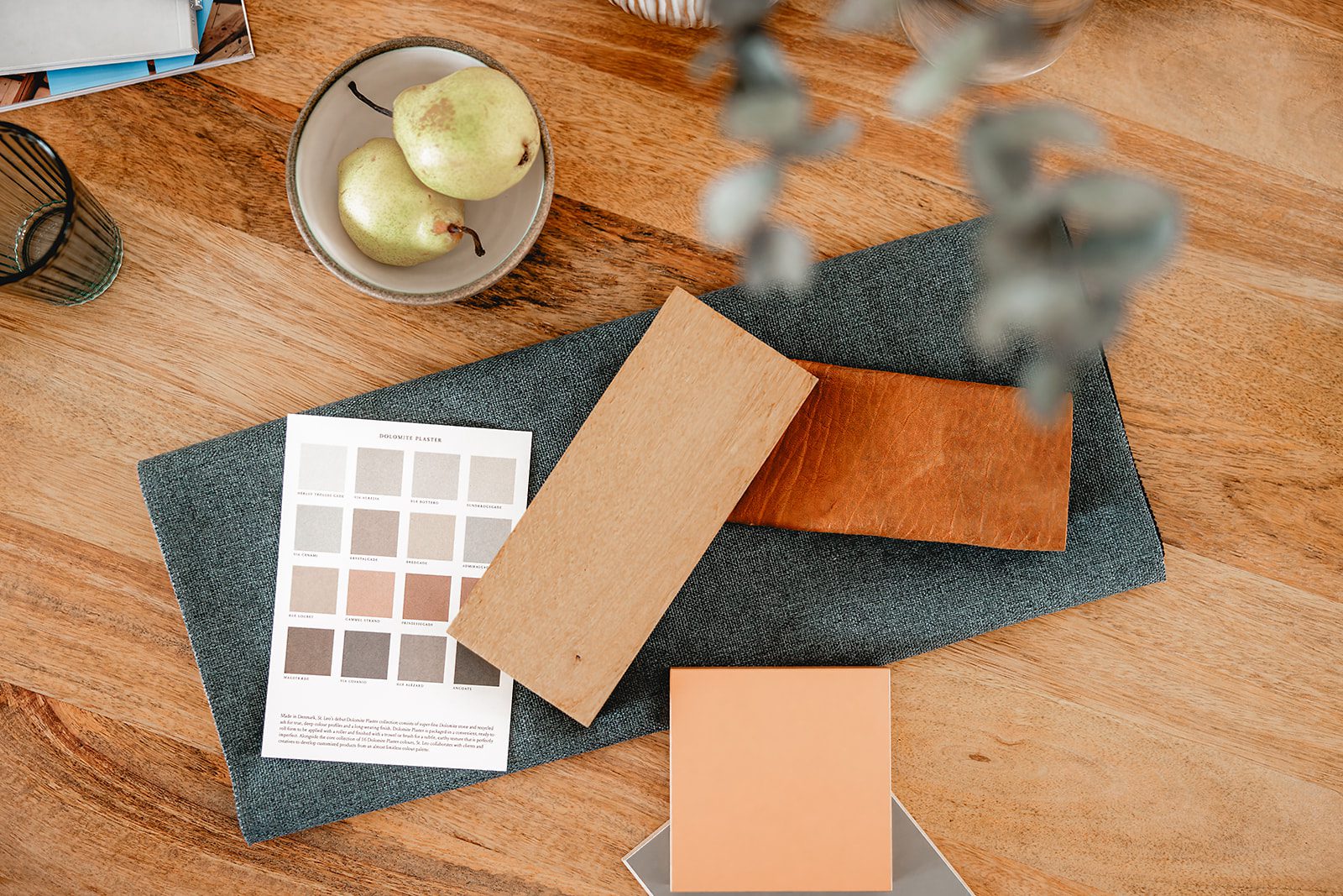 Material- und Farbmuster für ein Gestaltungskonzept liegen auf einem Holztisch für eine Umbauberatung bereit.